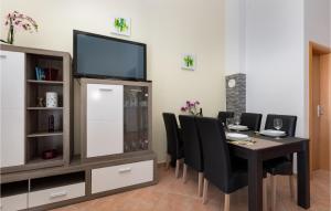 a dining room with a table with chairs and a tv at Beautiful Apartment In Cizici With Kitchen in Čižići
