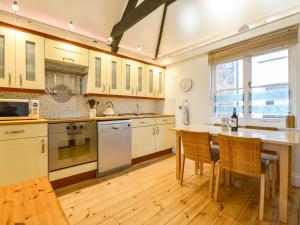 a large kitchen with a table and chairs in it at Chough Cottage in Cawsand