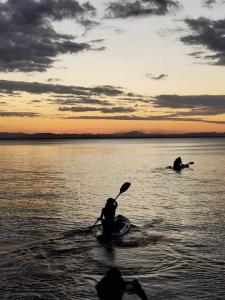 Zwei Leute fahren bei Sonnenuntergang auf dem Wasser mit dem Kajak in der Unterkunft Cabañas Privadas Dilany in Moyogalpa