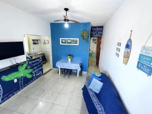 a dining room with a table and a blue wall at Casa Mar Peruíbe in Peruíbe