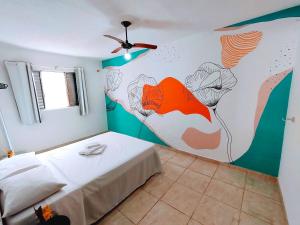 - une chambre ornée d'une fresque murale représentant des fleurs dans l'établissement Casa Mar Peruíbe, à Peruíbe