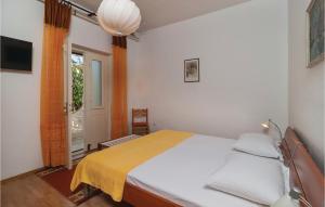 a bedroom with a bed with a yellow blanket at Stunning Apartment In Supetar With 2 Bedrooms And Wifi in Supetar