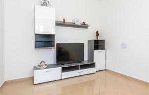 ein Wohnzimmer mit einem Flachbild-TV an der Wand in der Unterkunft Cozy Apartment In Rogoznica With Wifi in Rogoznica