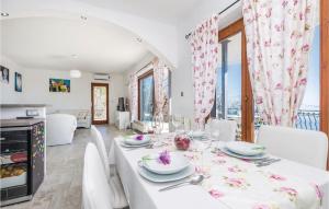 a dining room with a white table and white chairs at Amazing Apartment In Matulji With House Sea View in Matulji