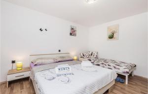 a white bedroom with two beds and two candles at Pet Friendly Home In Rijeka With Wifi in Rijeka