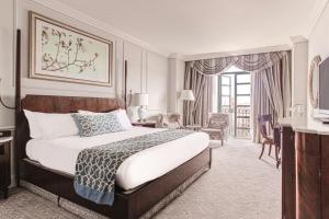 um quarto com uma cama king-size e uma sala de estar em The Charleston Place em Charleston