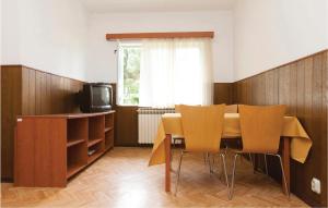ein Esszimmer mit einem Tisch, Stühlen und einem TV in der Unterkunft Gorgeous Apartment In Rovinj With Kitchen in Rovinj