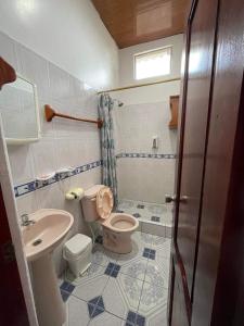 y baño con aseo y lavamanos. en Hostal Muro De Las Lagrimas with high speed internet Starlink, en Puerto Villamil