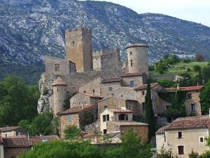 um grande castelo no meio de uma aldeia em Gîte la Chèvre d'Or em Aniane