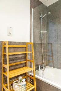a bathroom with a shower and a bath tub with a ladder at Attractive 2 Bedroom Penthouse with free Parking in Romford
