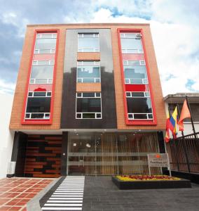 un edificio con dos banderas delante en Hotel Castellana 100, en Bogotá