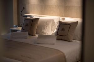 ein weißes Bett mit zwei Kissen und einem Kopfteil in der Unterkunft Best Western Plus Hotel Terre di Eolo in Patti
