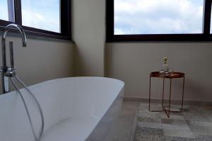 ein Badezimmer mit einer Badewanne und einem Tisch in der Unterkunft Best Western Plus Hotel Terre di Eolo in Patti