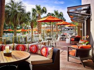 
a patio area with tables, chairs and umbrellas at Sonesta Resort - Hilton Head Island in Hilton Head Island
