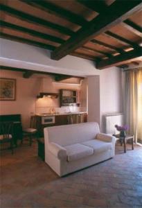 Agriturismo Torraiolo في باربرينو فال دالسا: غرفة معيشة مع أريكة بيضاء ومطبخ