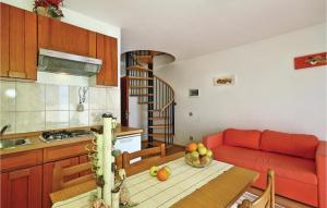 a kitchen and living room with a table and a red couch at Amazing Apartment In Tar-vabriga With Kitchen in Vabriga