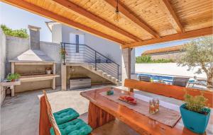 eine Terrasse mit einem Holztisch und einem Kamin in der Unterkunft Gorgeous Apartment In Pula With Kitchen in Muntić