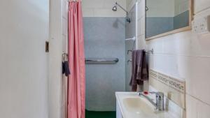 Un baño con cortina de ducha y lavabo. en Golden Peak Motel PeakHill, en Peak Hill 65 fotos más