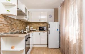 una cucina con armadietti bianchi e frigorifero di Stunning Home In Zubovici With House Sea View a Zubovići