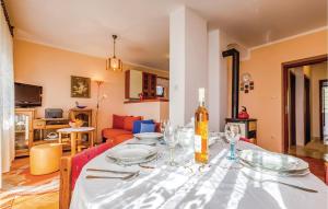 uma mesa de jantar com copos e uma garrafa de vinho em Amazing Apartment In Novi Vinodolski With Kitchen em Novi Vinodolski