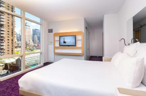 a hotel room with a bed and a tv at YOTEL New York Times Square in New York