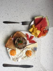 un plato de comida con huevos y fruta en una mesa en Casa Dolcecr, en Esterillos