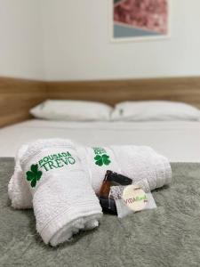 uma pilha de toalhas em cima de uma cama em Hotel Trevo Caruaru em Caruaru