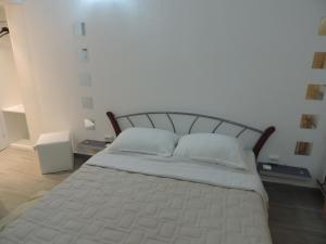 1 dormitorio con 1 cama con sábanas y almohadas blancas en Guesthouse Nikola, en Lagos de Plitvice