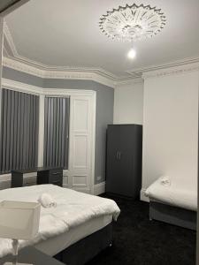 a bedroom with two beds and a chandelier at New modern Private House central location in Newcastle upon Tyne