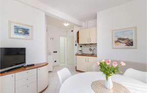 ein Wohnzimmer mit einem Tisch und einer Blumenvase in der Unterkunft Amazing Apartment In Medulin With Kitchen in Medulin