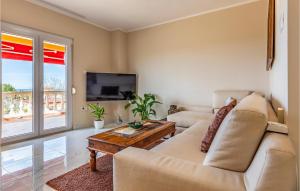 un salon avec un canapé et une table dans l'établissement Three-Bedroom Apartment In Vodnjan, à Mednjan