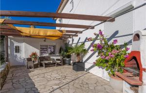 a patio with awning and flowers and a table at Beautiful Apartment In Vrbnik With Kitchen in Vrbnik