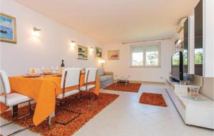 uma sala de jantar com mesa e cadeiras em Amazing Apartment In Njivice With Wifi em Njivice