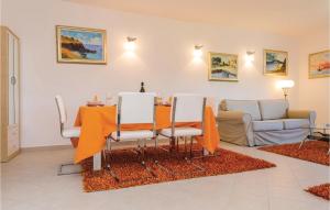 uma mesa de jantar e cadeiras numa sala de estar em Amazing Apartment In Njivice With Wifi em Njivice