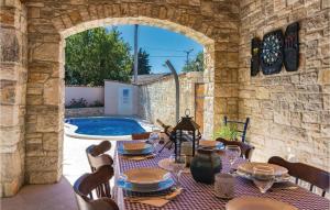 een patio met een tafel en stoelen en een zwembad bij Lovely Home In Barban With Kitchen in Barban