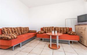 a living room with two couches and a table at Beautiful Apartment In Njivice With Kitchen in Njivice