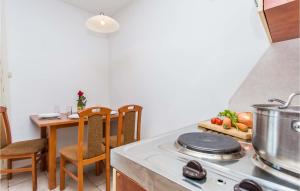 a kitchen with a stove top oven next to a table at Beautiful Apartment In Njivice With Kitchen in Njivice