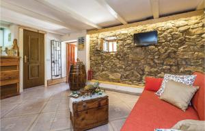 a living room with a red couch and a stone wall at Lovely Home In Jurdani With Outdoor Swimming Pool in Jurdani