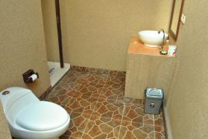 a bathroom with a toilet and a sink at Sudi Guest House in Pemuteran