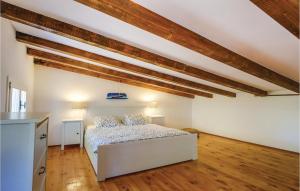 een slaapkamer met een bed in een kamer met houten balken bij 1 Bedroom Lovely Home In Cunski in Čunski