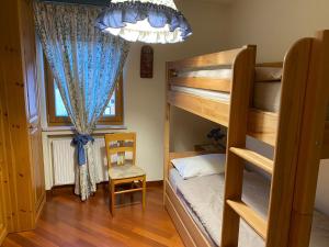 ブレッサノーネにあるCASA DI PITTOのベッドルーム1室(二段ベッド2台、椅子付)
