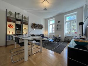 een grote woonkamer met een tafel en stoelen bij Vienna Design Apartment by Rabe - kostenfreier Parkplatz & Netflix & Coffee-Bar - nahe Schloss Schönbrunn in Wenen