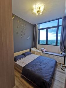 een slaapkamer met 2 bedden en een raam bij Super Cozy and Stylish Micasa 3 home- Hann's Residence in Sibu