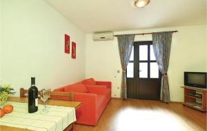 a living room with a red couch and a table at Beautiful Apartment In Tar-vabriga With 1 Bedrooms And Wifi in Vabriga