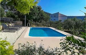 a swimming pool in a yard with chairs and trees at Awesome Home In Vinisce With Outdoor Swimming Pool in Vinišće