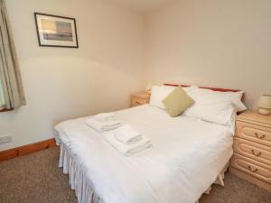 a bedroom with a white bed with two towels on it at MacKintosh in Pitlochry