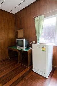 a room with a desk with a computer and a refrigerator at Sea Garden Resort & Spa, Haadrin in Haad Rin