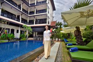 a woman is standing in front of a hotel at Khmer Mansion Boutique Hotel in Siem Reap