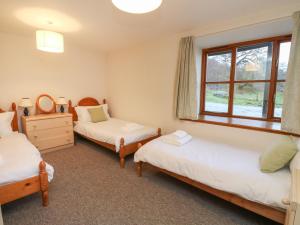 a bedroom with two beds and a window at Campbell in Pitlochry