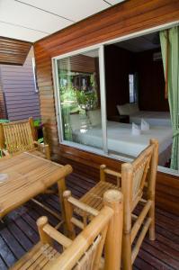 a screened in porch with a table and a window at Sea Garden Resort & Spa, Haadrin in Haad Rin